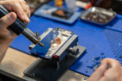 Cropped hands of man repairing circuit board