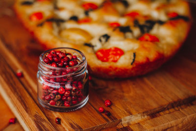 Close-up of food on table. homemade italian focaccia, with tomato, pink pepper and olive oil.