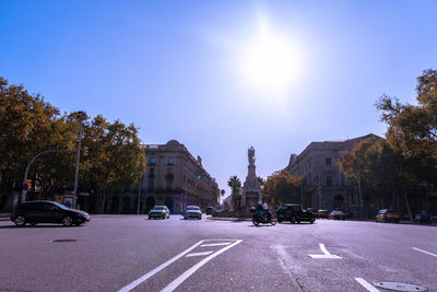 Cars on city street against sky