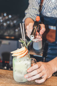 Mid section of a man preparing cocktail