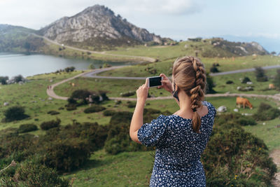 Full length of woman photographing at camera