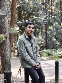 Portrait of young man standing in forest