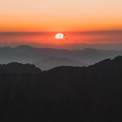 Scenic view of silhouette mountain against orange sky