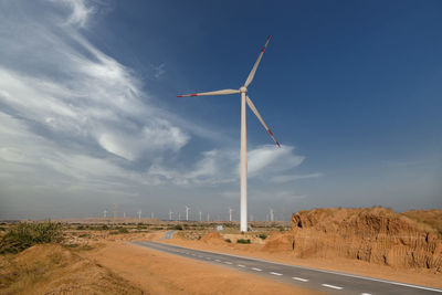 Windmill on field against sky