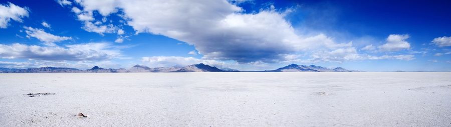 Panoramic view of arid landscape against blue sky