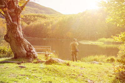 People standing on land by trees