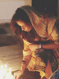 Midsection of woman holding burning candle
