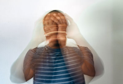 Low section of woman holding heart shape against white background