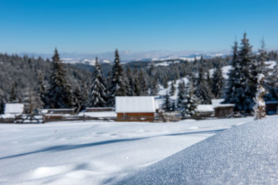 Snow covered field against clear blue sky