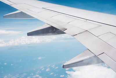 Cropped image of airplane flying over blue sky