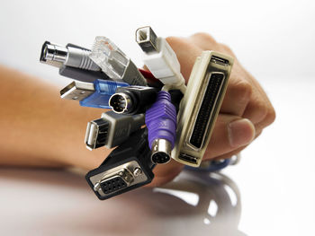 Close-up of hand holding camera against white background