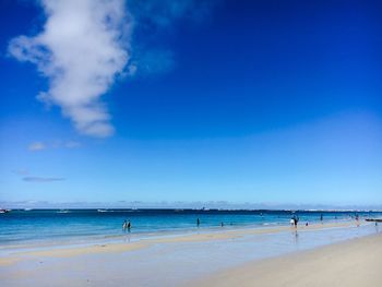 Scenic view of beach against blue sky