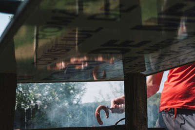 Mid section of man barbecuing sausages