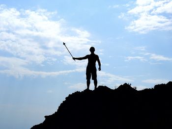 Low angle view of silhouette man standing against sky