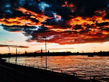 Scenic view of sea against cloudy sky at sunset