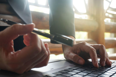 Close-up of man using smart phone on table