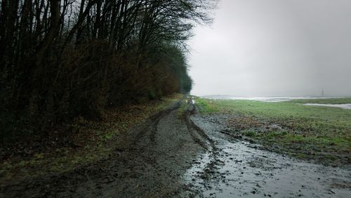 Road amidst field against sky