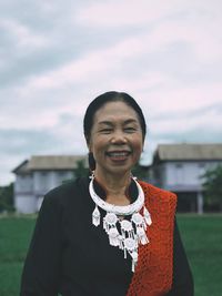 Portrait of smiling woman standing against sky