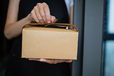 Midsection of woman holding box