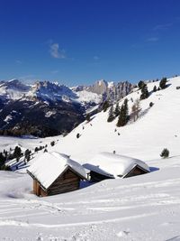 Scenic view of snow covered mountains against blue sky