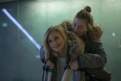 Young woman giving piggyback to friend 