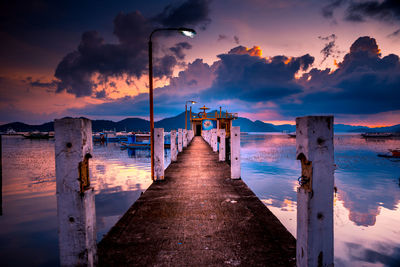 Pier over sea against sky during sunset