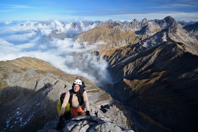 Man sitting on rocks against mountains