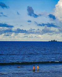 Children playing along the beach in the philippines, with the pacific ocean in the background.