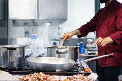 Midsection of chef preparing food in kitchen