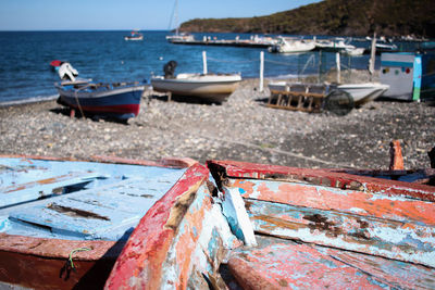 Close-up of boats moored in sea against sky