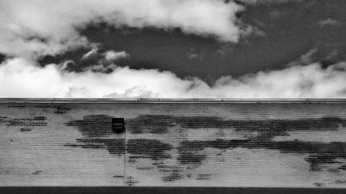 Wall against cloudy sky