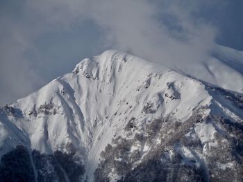 Low angle view of snowcapped mountain against sky