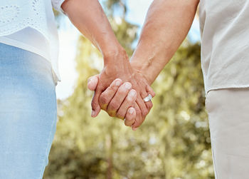 Midsection of couple holding hands