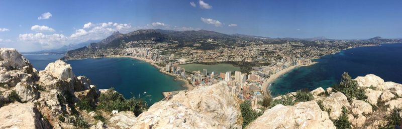 High angle view of sea and mountains against blue sky