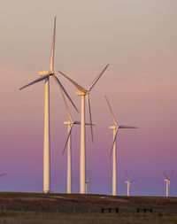 Wind turbine farm against beautiful sky during sunset