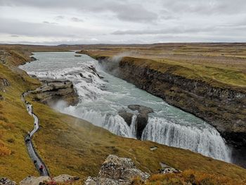 Scenic view of waterfall against sky