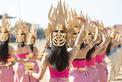 Rear view of women wearing costumes dancing at event