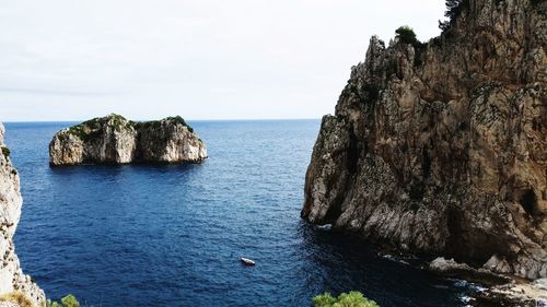 Rock formation in sea against sky