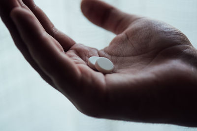 Close-up of cropped hand holding medicines at home