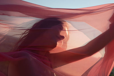 Full length portrait of woman standing in sunlight