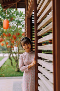 Portrait of smiling woman standing at doorway