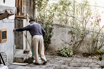 Rear view of man standing against wall