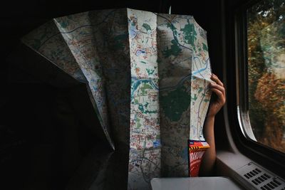 Person holding map while sitting in train