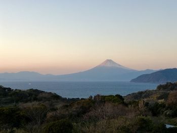 Scenic view of sea and mountains against clear sky