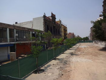 Footpath amidst buildings against sky in city