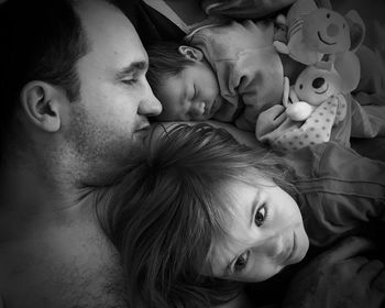 High angle view of father with children lying on bed