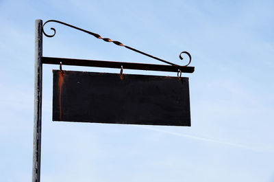 Low angle view of sign board against sky