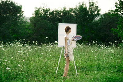 Woman with umbrella standing on field