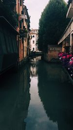 Canal amidst buildings against sky