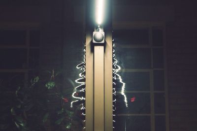 Low angle view of illuminated light bulb in darkroom